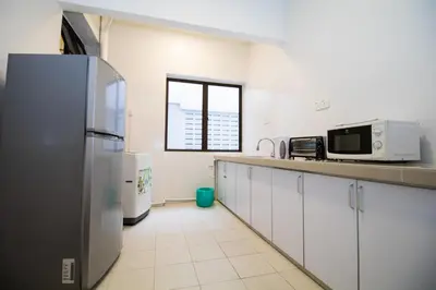 a kitchen with white cabinets and a refrigerator at Arcadia Penang by Plush in George Town