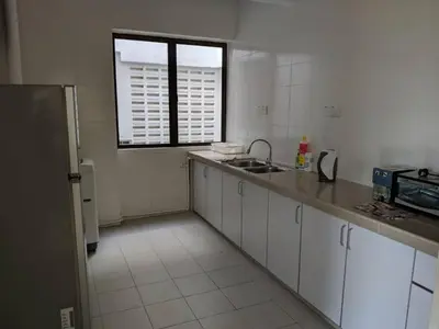 a kitchen with white cabinets and a sink and a window at Arcadia Penang by Plush in George Town
