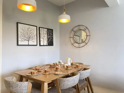 a dining room with a table with chairs and a mirror at Arcadia Penang by Plush in George Town