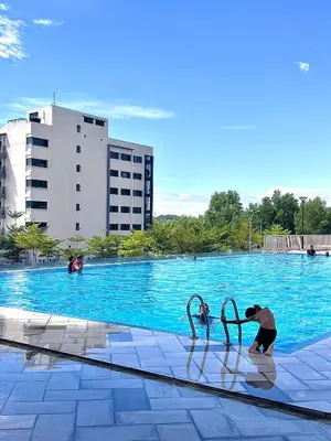 a man is standing next to a swimming pool at Casahome by Irdina Meru- 8pax -10pax in Ipoh