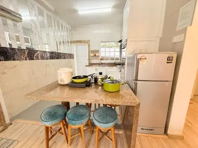 a kitchen with a counter with stools and a refrigerator at The Haven Retreat B7-2-1 ( Silverpark) in Bukit Fraser