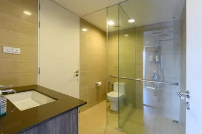 a bathroom with a shower and a sink and a toilet at By The Sea Beach Front Apartment in Batu Ferringhi