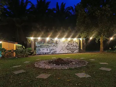 a fire pit in a yard at night with lights at Outworld Basecamp in Gopeng