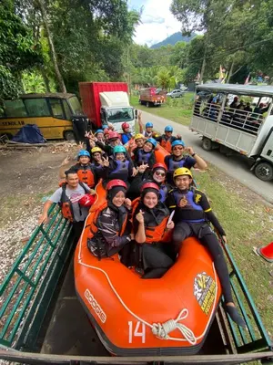 a group of people riding on an orange raft at Outworld Basecamp in Gopeng