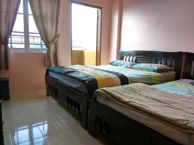 two beds in a room with a window at Tenang & Tranquil Homestay - B605 Cameron Highlands in Brinchang