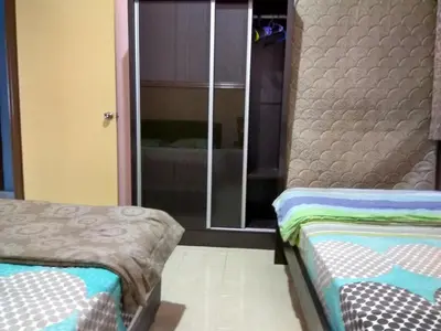 two beds in a room with a mirror at Tenang & Tranquil Homestay - B605 Cameron Highlands in Brinchang