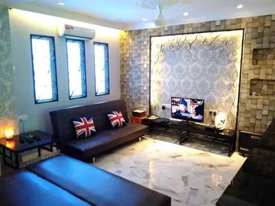 a living room with a couch and a television at Fastbook Majestic Home 10pax in Ayer Itam