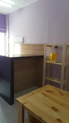 a kitchen with a wooden counter and a wooden table at Cottage Muslim Homestay ByWawaSha in Tanjung Malim