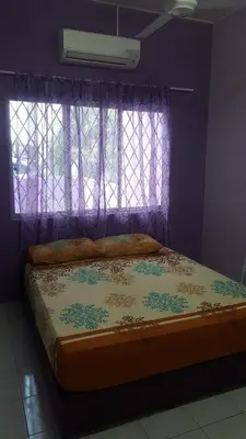 a bed in a purple room with a window at Cottage Muslim Homestay ByWawaSha in Tanjung Malim