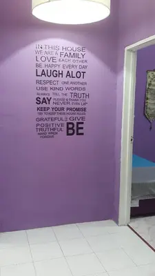 a wall with writing on it with a purple wall at Cottage Muslim Homestay ByWawaSha in Tanjung Malim