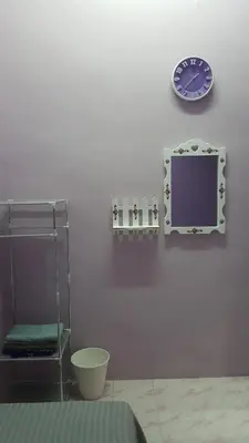 a wall with a clock and a shelf and a clock at Cottage Muslim Homestay ByWawaSha in Tanjung Malim