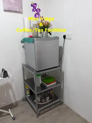 a tv on a cart next to a wall at Yellow Cube at Lumut Cube Homestay Kontena in Lumut