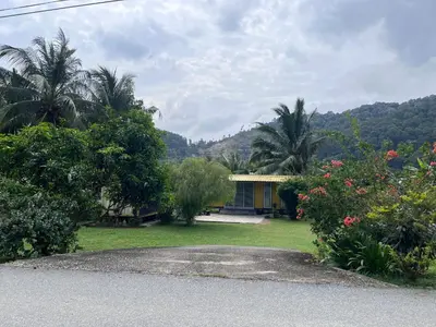 a house with a yard with trees and flowers at Yellow Cube at Lumut Cube Homestay Kontena in Lumut