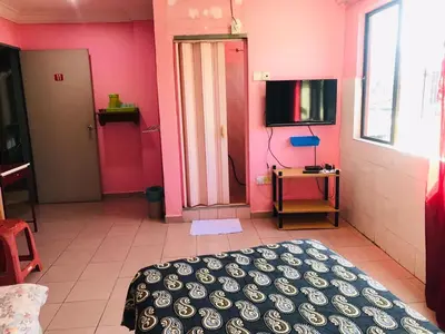 a bedroom with pink walls and a bed and a tv at Hotel Cahaya in Tanjung Malim
