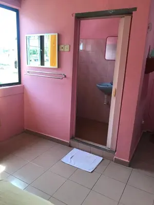 a pink bathroom with a shower and a sink at Hotel Cahaya in Tanjung Malim