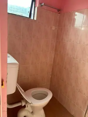 a bathroom with a toilet and a window at Hotel Cahaya in Tanjung Malim