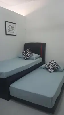 two beds sitting next to each other in a room at Homestay / Roomstay Muslim Budget Tanjung Malim in Tanjung Malim