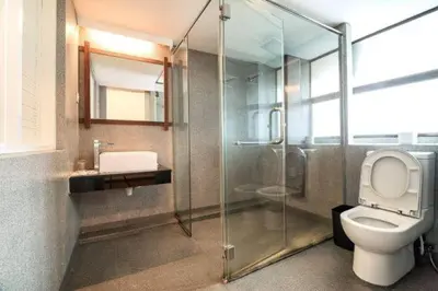 a bathroom with a toilet and a glass shower at The Boutique Residence Hotel in George Town