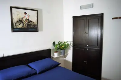 a bedroom with a bed and a picture of a bike on the wall at Great Shanghai Guesthouse in George Town