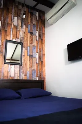 a bedroom with a mirror on the wall and a bed at Great Shanghai Guesthouse in George Town
