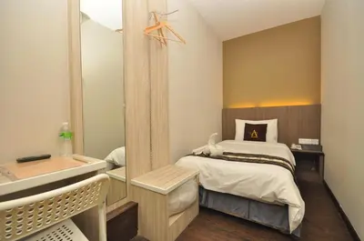 a small bedroom with a bed and a sink at Art Cottage Hotel in Ipoh