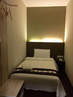 a bedroom with a large bed with lights on it at Art Cottage Hotel in Ipoh