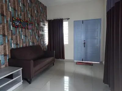a living room with a couch and a blue door at Teratak Delisha -musslim in Kampong Jemampar