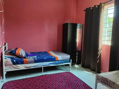 a bedroom with a bunk bed and a red wall at Teratak Delisha -musslim in Kampong Jemampar
