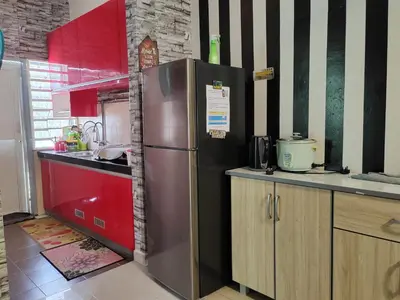 a kitchen with a stainless steel refrigerator and red cabinets at Teratak Delisha -musslim in Kampong Jemampar
