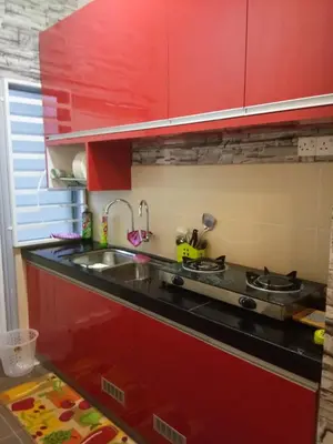 a kitchen with red cabinets and a sink at Teratak Delisha -musslim in Kampong Jemampar