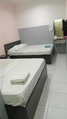 two beds in a room with a mirror at Hotel Checkedinn in Ipoh
