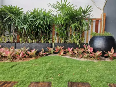 a garden with pink flowers and a wooden fence at Frame Hotel in George Town