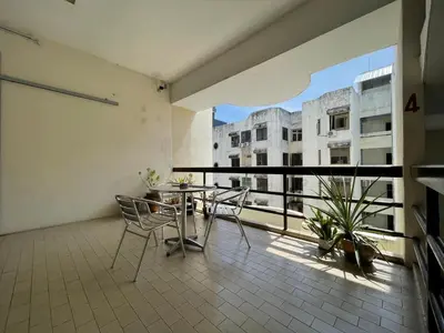 a balcony with a table and chairs and a view of a building at Hotel O Wg Guest House in George Town
