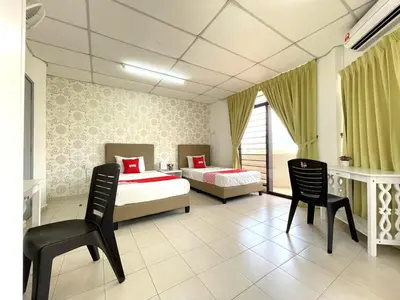 a bedroom with two beds and two chairs at Hotel O Wg Guest House in George Town