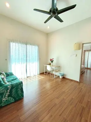 a living room with a ceiling fan and a table at TROPICAL LIVINGS MERU IPOH HOMESTAY by Grab A Stay in Ipoh
