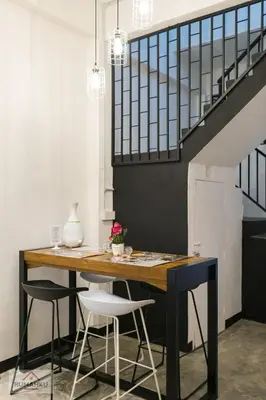 a table in a room with two chairs and a staircase at Rumahku Express, Georgetown, Penang in George Town