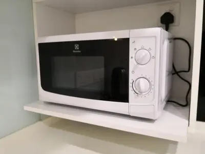 a white microwave sitting on a white shelf at Strait Garden Suites X Ace Pro @ George Town in Jelutong