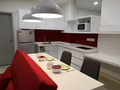 a kitchen with a table with chairs and a microwave at Strait Garden Suites X Ace Pro @ George Town in Jelutong