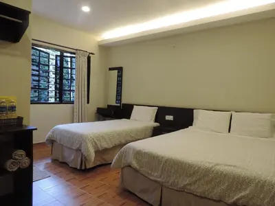 a hotel room with two beds and a window at Cameronian Inn in Cameron Highlands