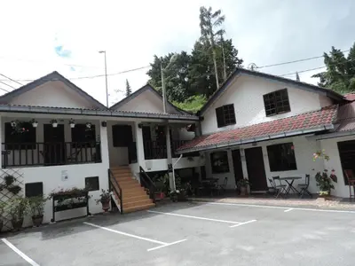 a building with a parking lot in front of it at Cameronian Inn in Cameron Highlands
