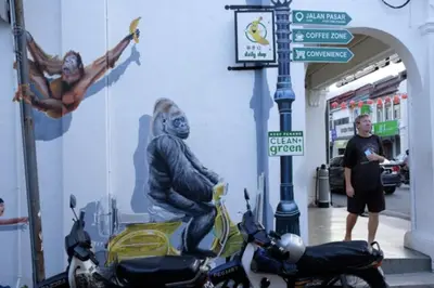 a man standing in front of a wall with a monkey on a motorcycle at The Landmark Condo, by Sanguine in George Town