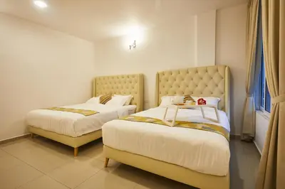 a bedroom with two beds with white sheets at Ahn-Yi Residence in Brinchang