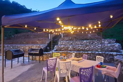 a blue tent with a table and chairs and a grill at Ahn-Yi Residence in Brinchang