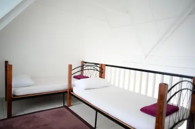 a balcony with two beds and two chairs at Tiny Boutique Habitat in Tanah Rata