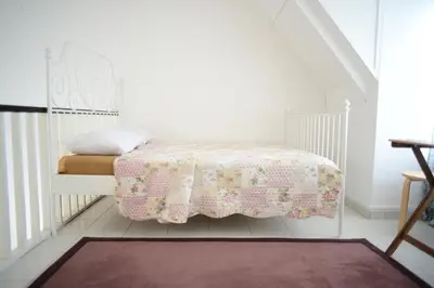a white bedroom with a bed with a pink blanket at Tiny Boutique Habitat in Tanah Rata