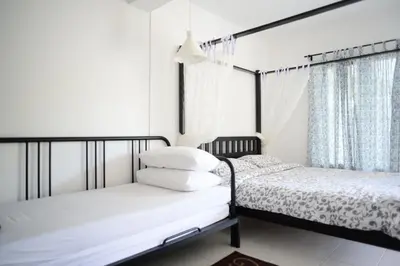 a bedroom with two beds and a window at Tiny Boutique Habitat in Tanah Rata
