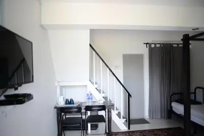 a room with a staircase and a table and chairs at Tiny Boutique Habitat in Tanah Rata
