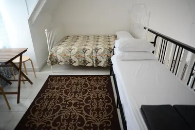 two beds in a small room with a staircase at Tiny Boutique Habitat in Tanah Rata