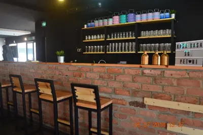a brick bar with three chairs against a brick wall at Hotel Seri Malaysia Sungai Petani in Sungai Petani