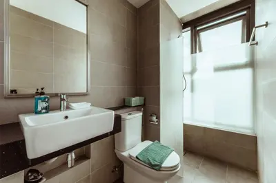 a bathroom with a toilet and a sink and a mirror at Muji X Tiffany - City and Hill View 3BR at 218 Tropicana NEAR Komtar Food Heaven with Netflix & TV Box in George Town